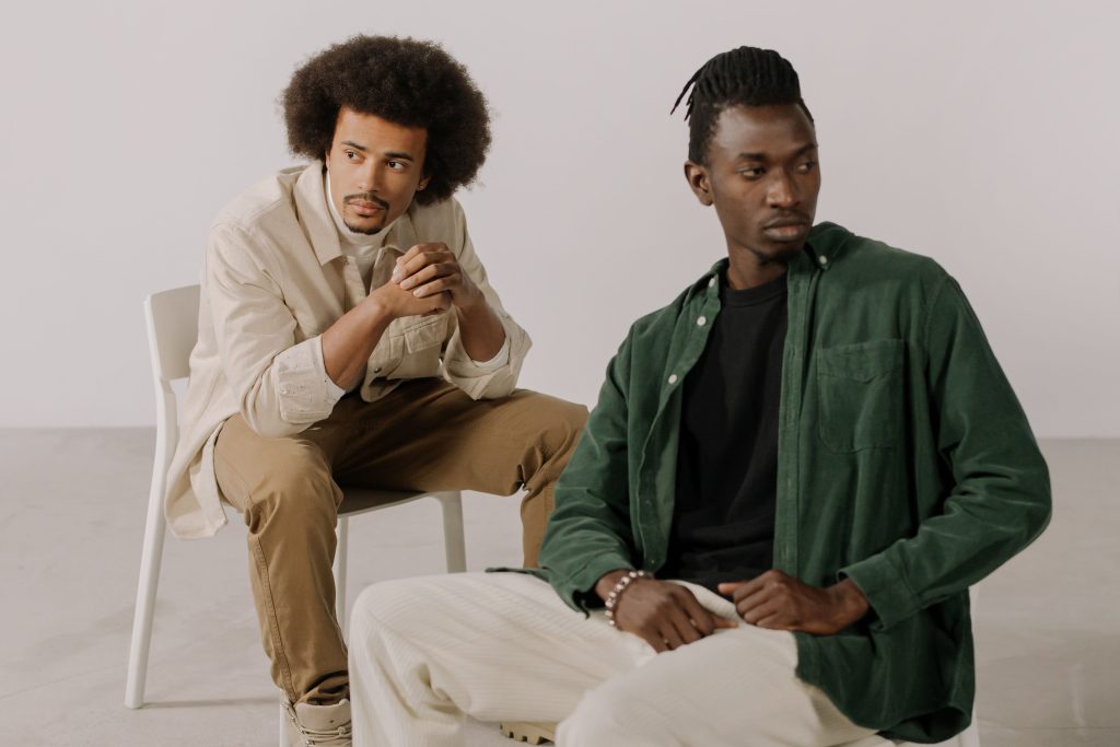 Two men wearing corduroy trousers and shirts.