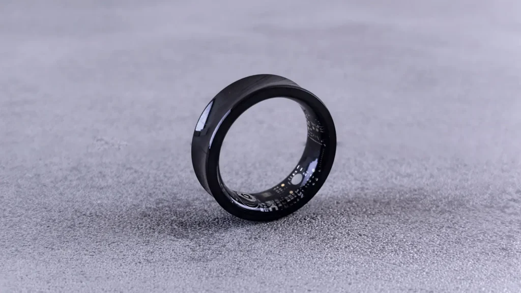 photo of a black smart ring for men, balancing on its side showing the sensors inside.